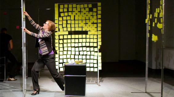 Satire über Selbstausbeutung und Karrieredenken: Gelbe Post-its und Notebooks sind Annes (Johanna Paliatsou) beste Freunde. Foto: MeyerOriginals / FWT