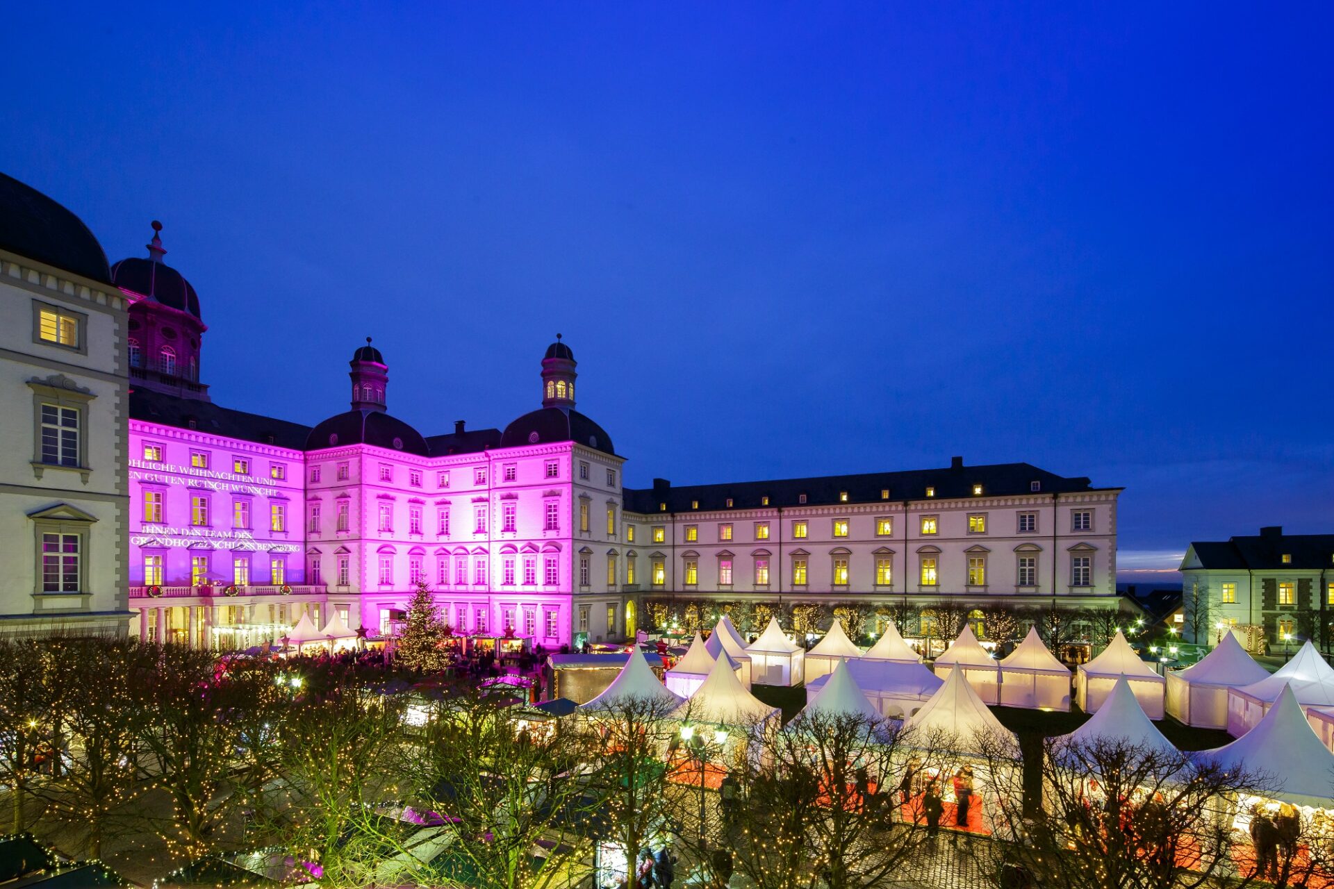 Das Foto zeigt das erstrahlte Schloss Bensberg mit Weihnachtsmarkt