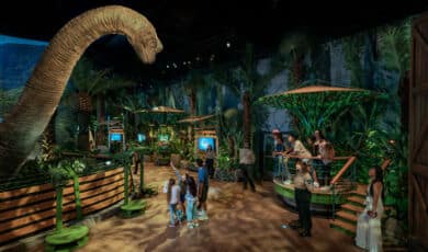 Besucher mit Dinosaurier bei der Jurassic World Ausstellung