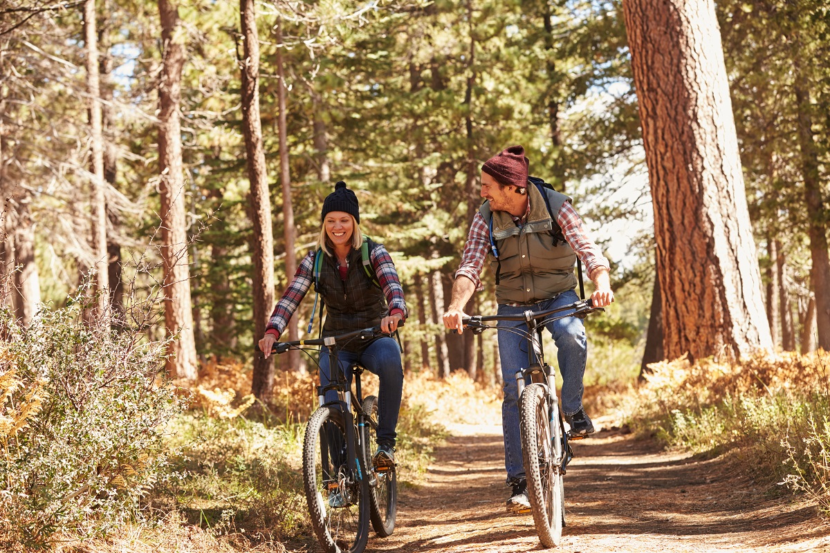 Ein Paar fahrt mit Fahrrädern durch den Wald.