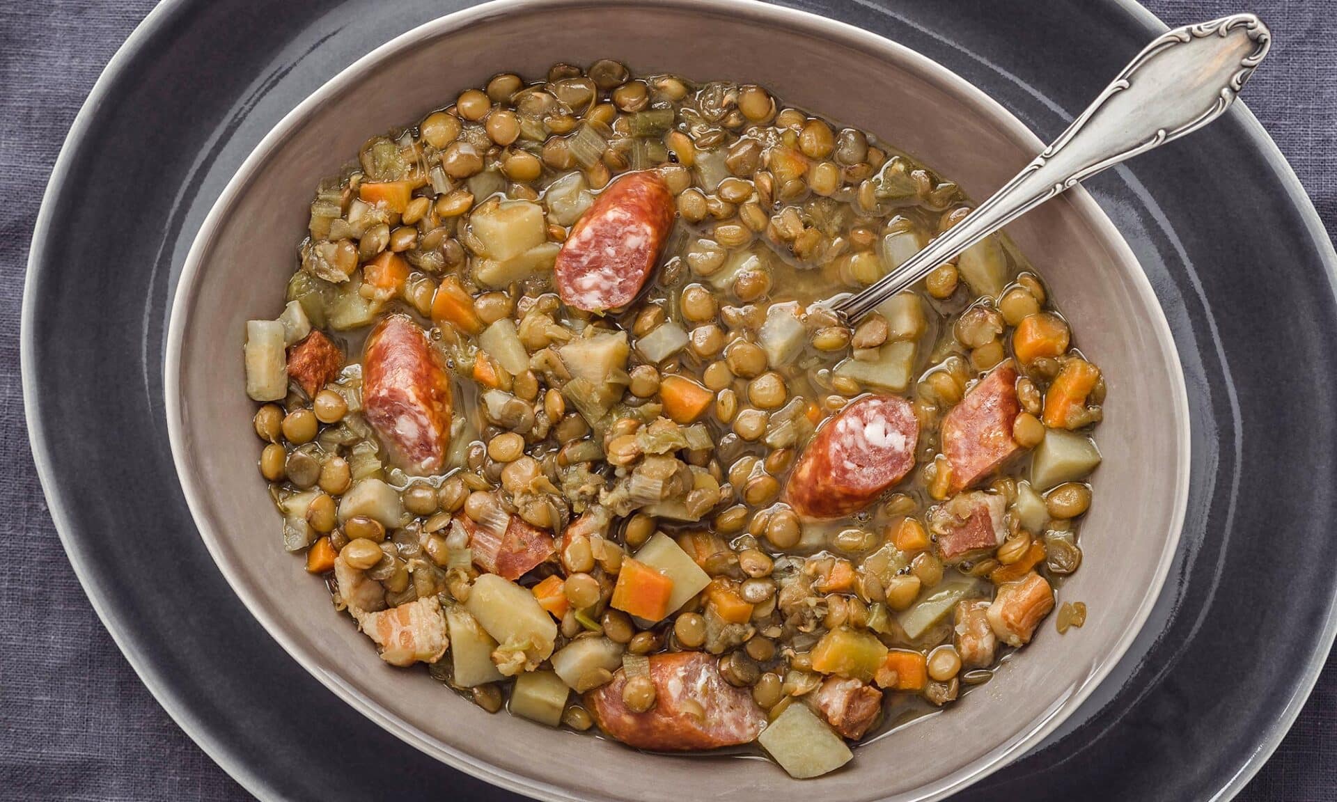 Ein Teller Linsensuppe mit Mettwurst.