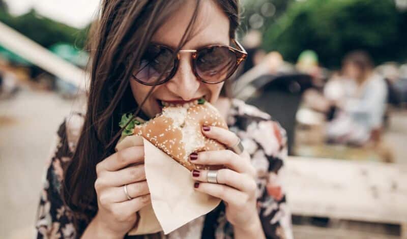 Frau isst Burger auf Food Festival