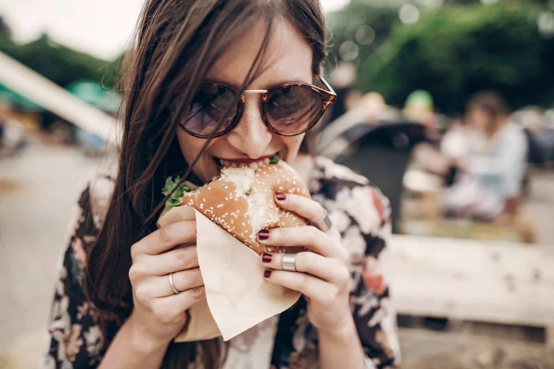 Frau isst Burger auf Food Festival