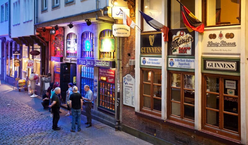 Besucher der Kölner Altstadt vor einer Kneipe.