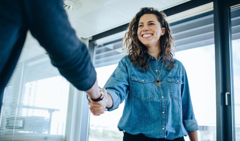 Frau gratuliert Bewerber zum neue Job.