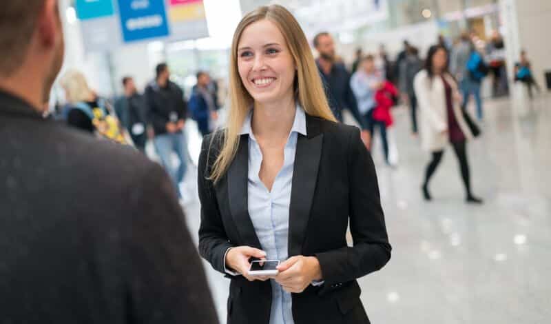 Junge Dame in Businesskleidung auf einer Messe