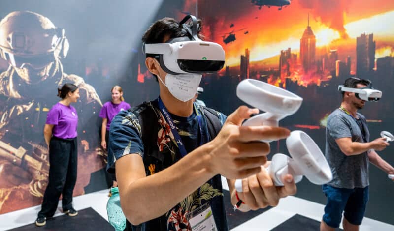 Das Foto zeigt einen Besucher der Gamescom, der ein Spiel mit aufgesetzter VR-Brille spielt.