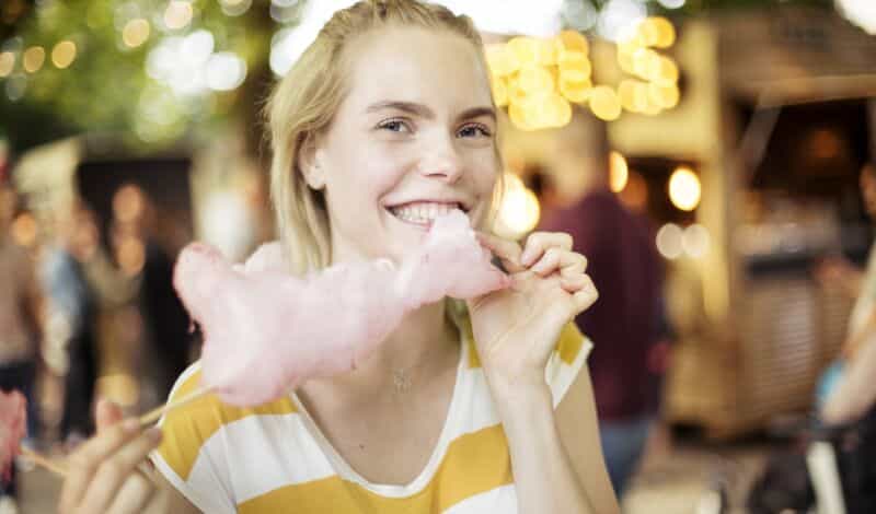 Junge Dame isst Zuckerwatte