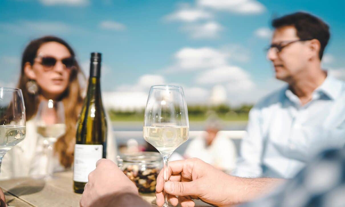 Genuss von Weißwein an einem Tisch im Sommer.