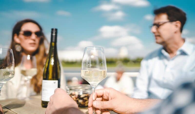 Genuss von Weißwein an einem Tisch im Sommer.