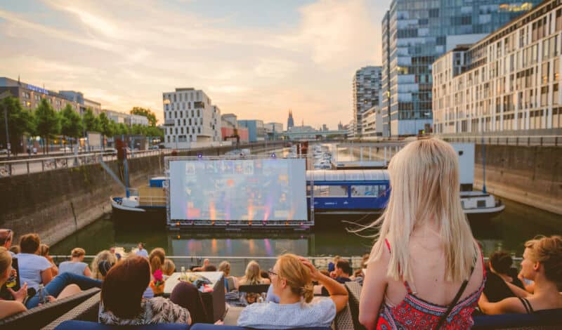 Das Foto zeigt die schwinmende Leinwand des openair Sommerkinos im Kölner Rheinauhafens.