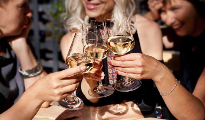 3 Frauen stoßen mit Wein an