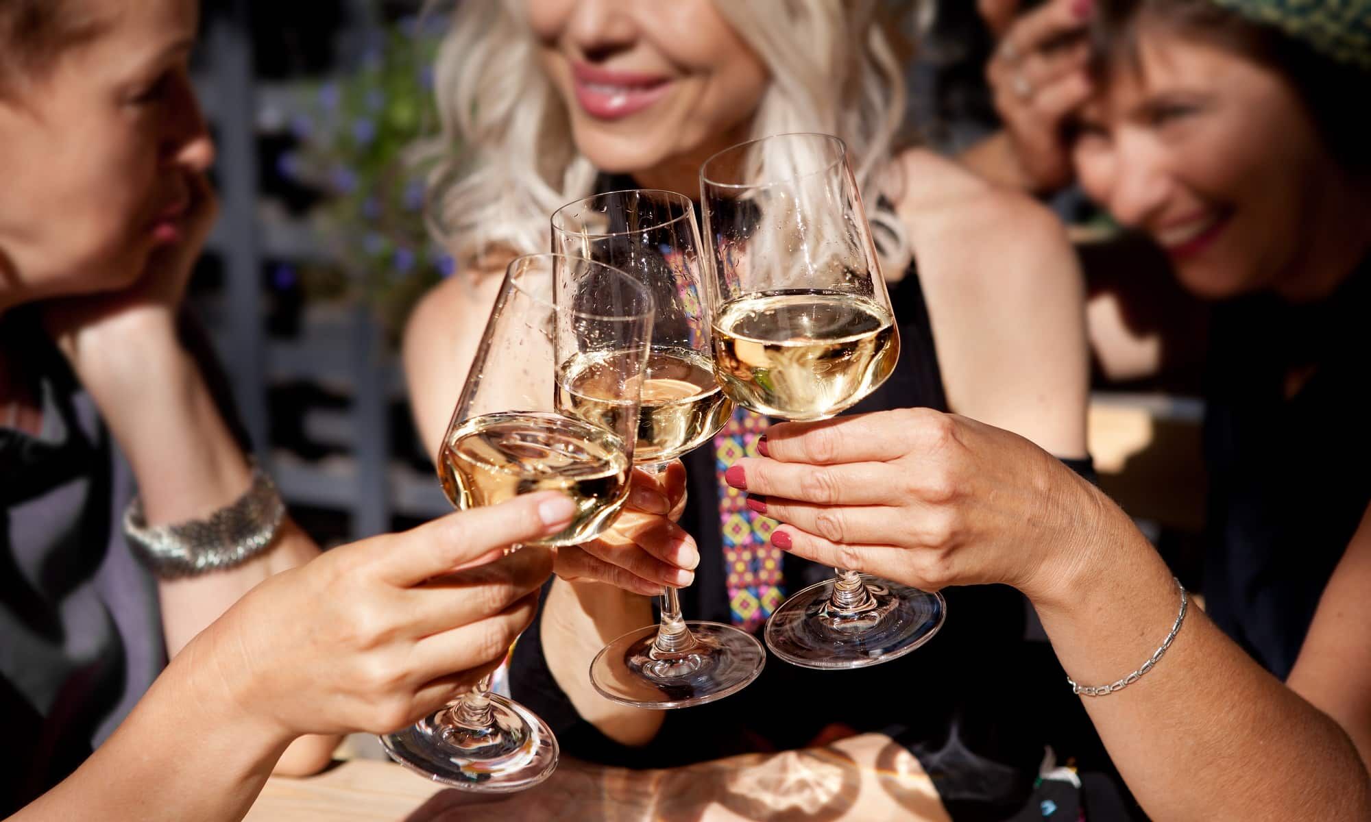 3 Frauen stoßen mit Wein an