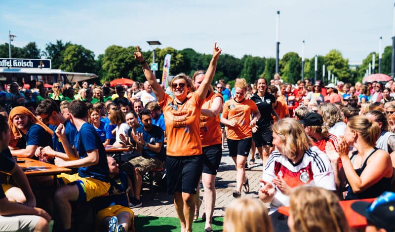 Jubelnde Teilnehmer des Come-Together-Cups auf den Stadionvorwiesen