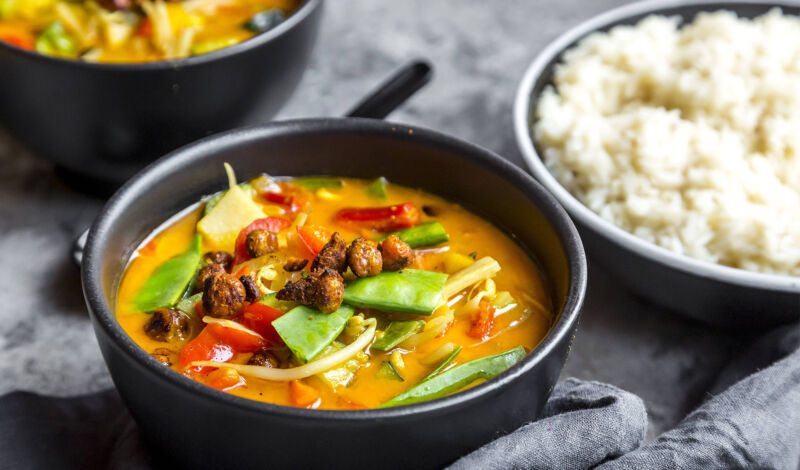 Ein asiatisches Curry mit Kichererbsen und Reis in einer Schale