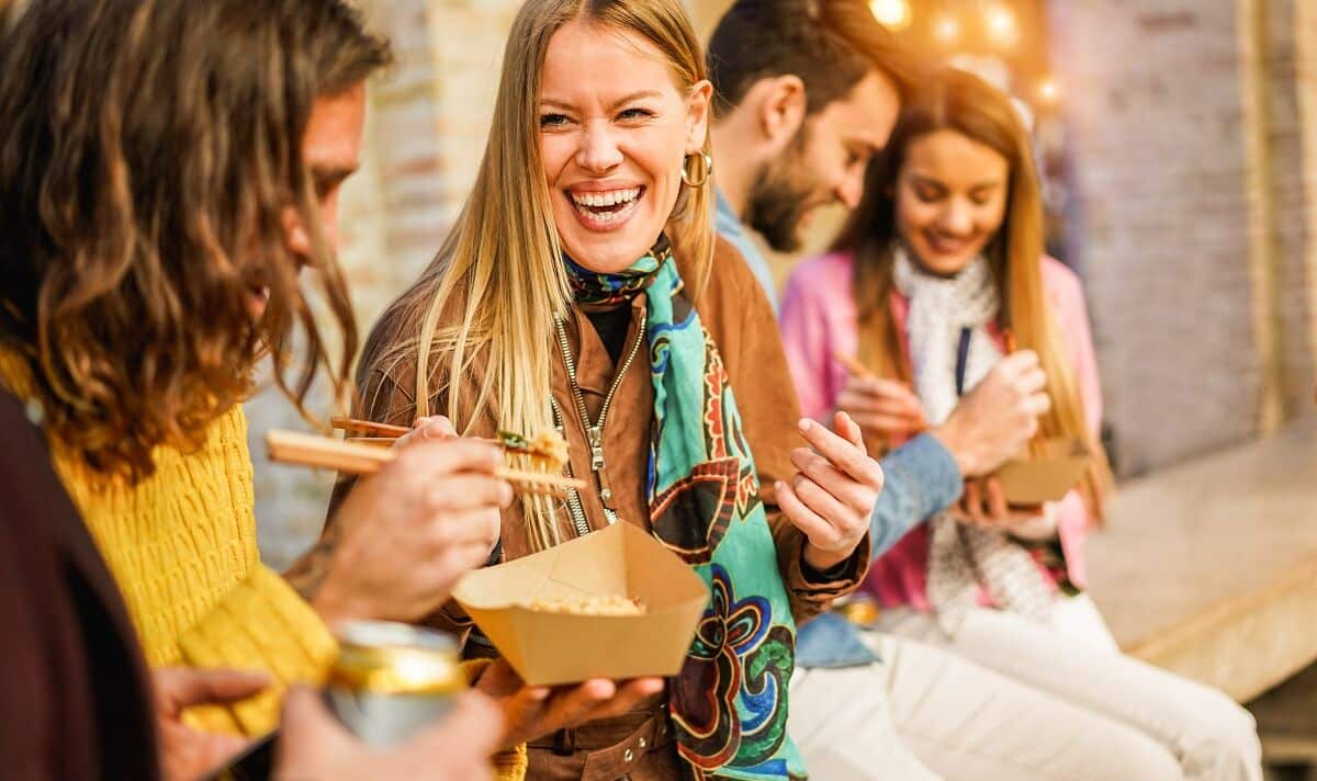 Personen essen Streetfood und haben Spaß