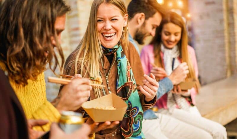 Personen essen Streetfood und haben Spaß