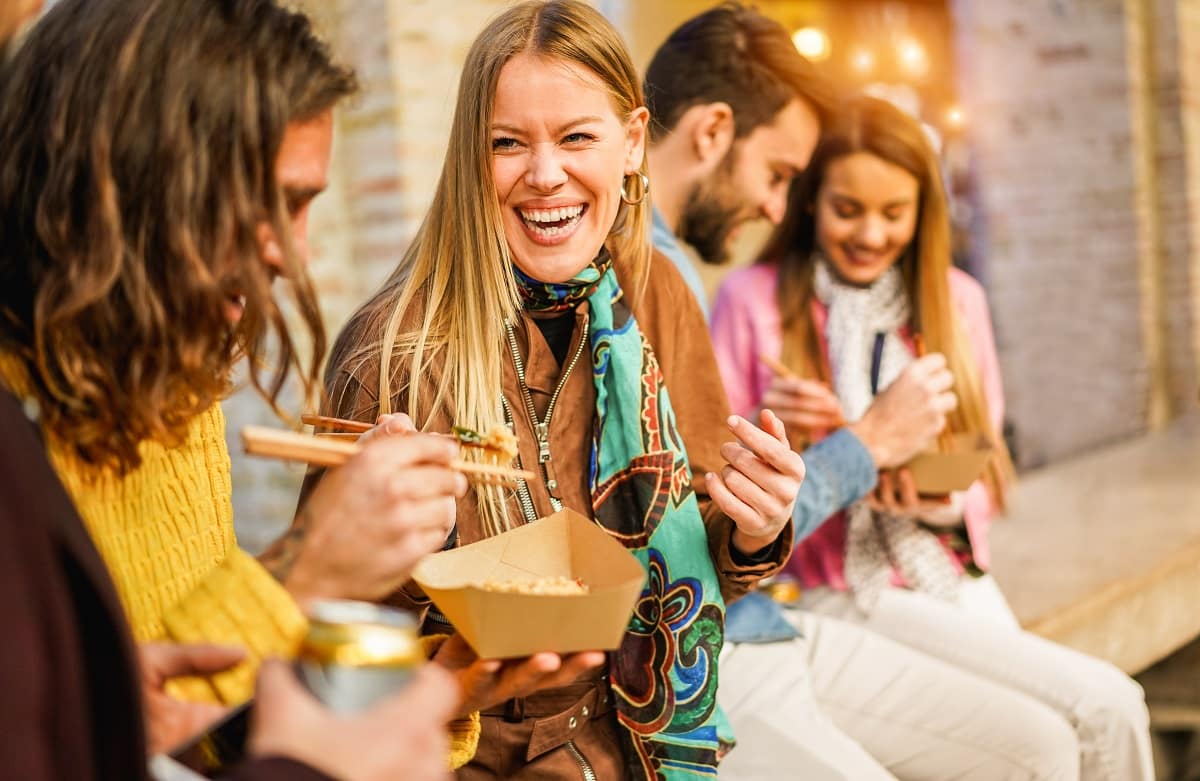 Personen essen Streetfood und haben Spaß