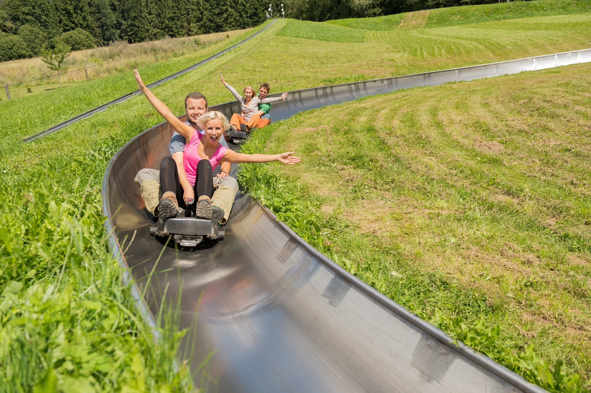 Paar auf einer Sommerrodelbahn im Panoramapark