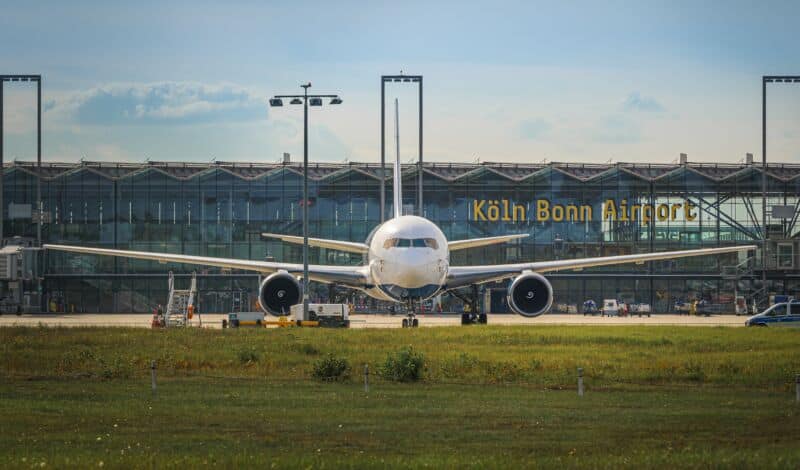 Flugzeug steht vor dem Gebäude des Flughafens Köln Bonn