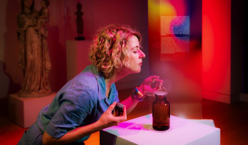 Frau riecht an Duft in der Ausstellung