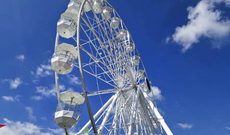 Ein Riesenrad vor strahlend blauem Himmel