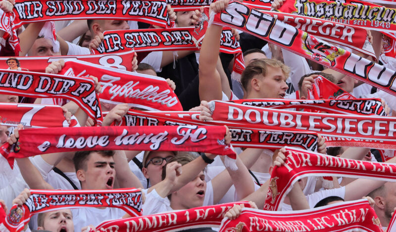 Fans des 1. FC Köln halten Schals ihres Vereins in die Luft