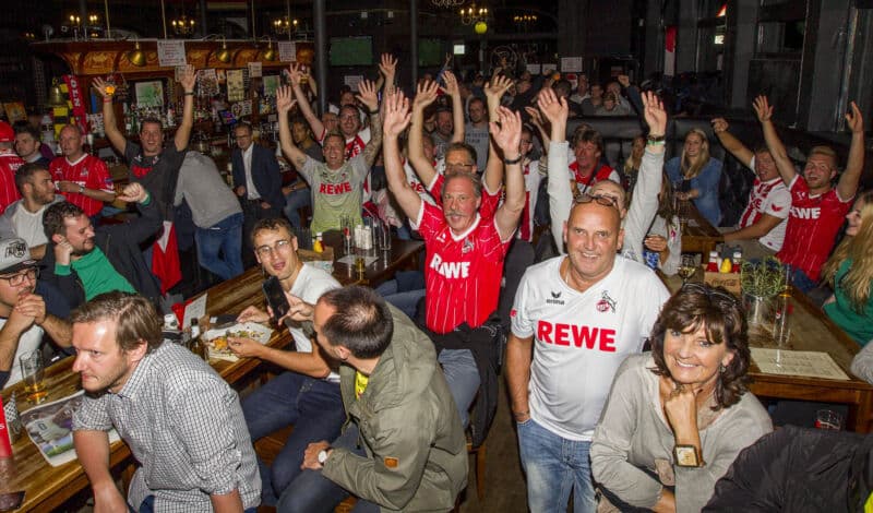 Fans des 1. FC Köln feiern in einer Fußballkneipe