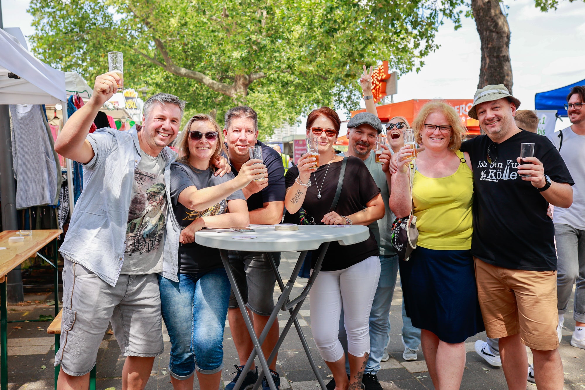 Menschen mit Getränken auf dem Rheinuferfest in Köln.