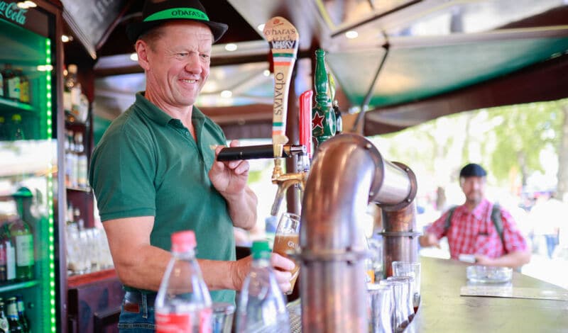 Mann zapft Bier in einem Getränkewagen