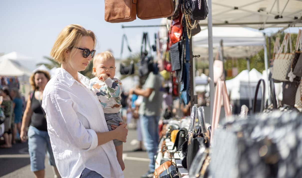 Frau mit Kleinkind an einem Flohmarkt-Stand
