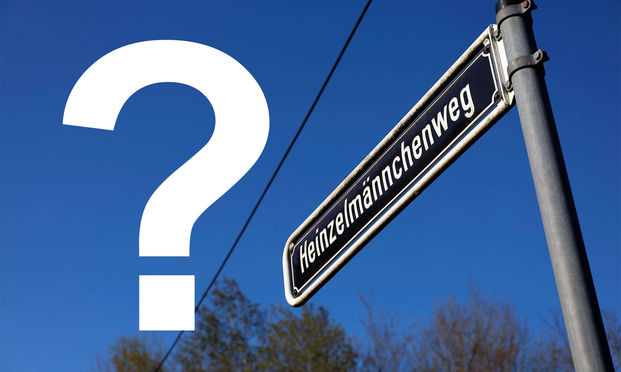 Ein Straßenschild mit der Beschriftung Heinzelmännchenweg sowie ein Fragezeichen vor blauem Himmel.