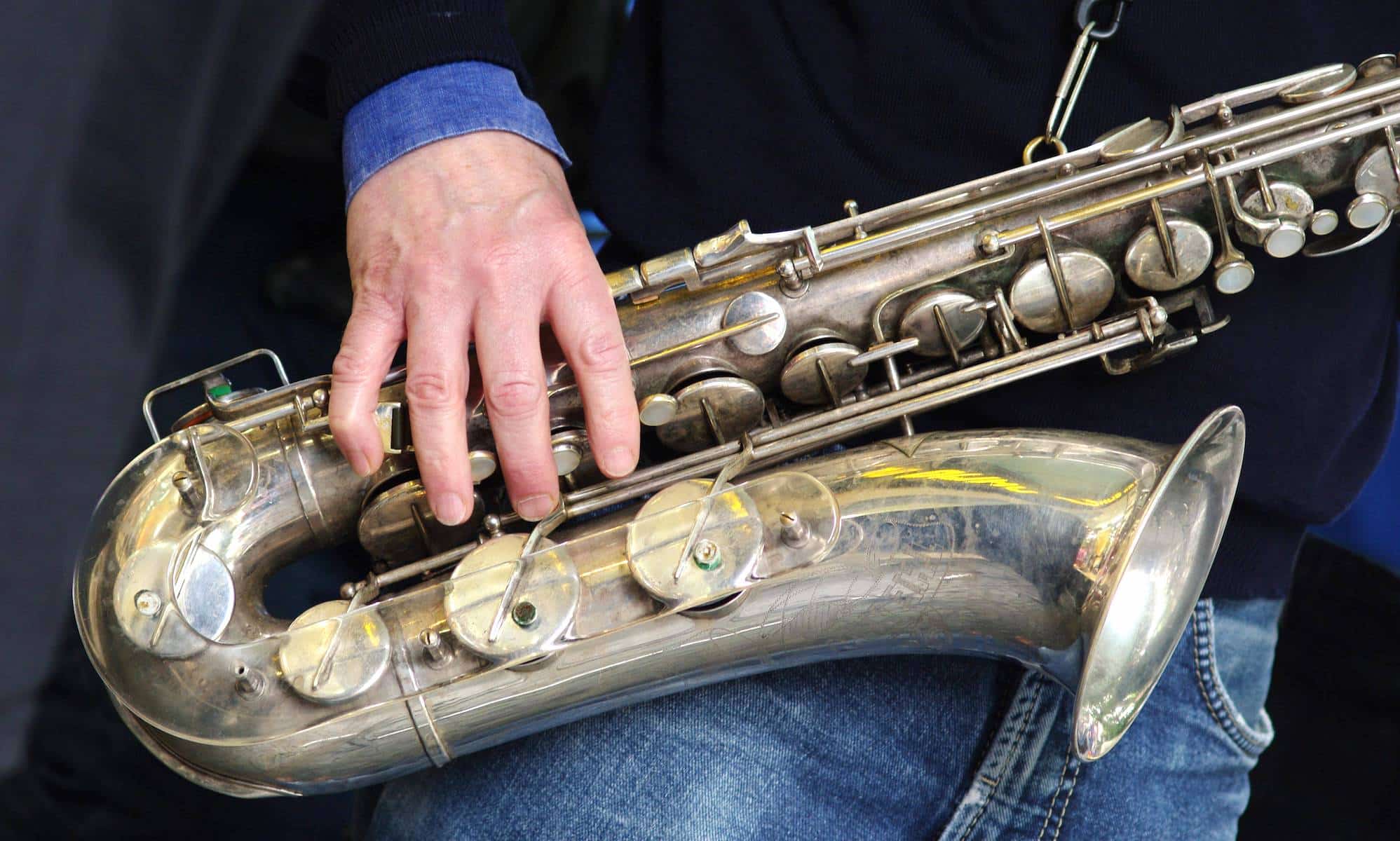 Nahaufnahme eines Saxofons, das ein Mann festhält