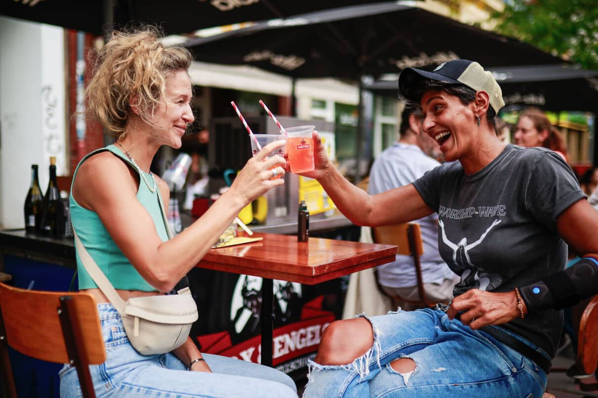 Zwei Menschen stoßen bei einem Straßenfest an.