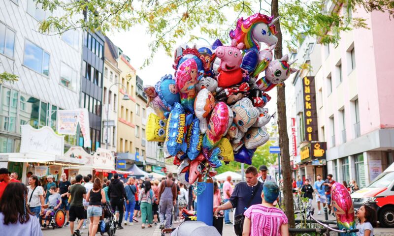 Südstadtfest 5 Das Foto zeigt einen Verkäufer mit vielen Luftballons bei einem Straßenfest in Köln.