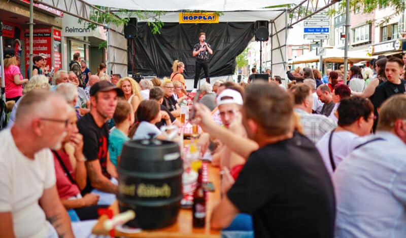 Besucher des Ehrenfelder Straßenfestes sitzen am Biertisch.