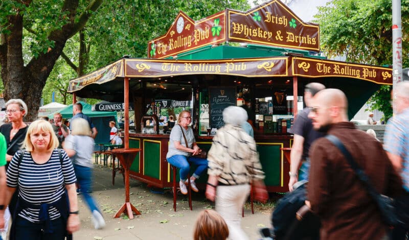 Besucher eines Straßenfests an einem Getränkewagen