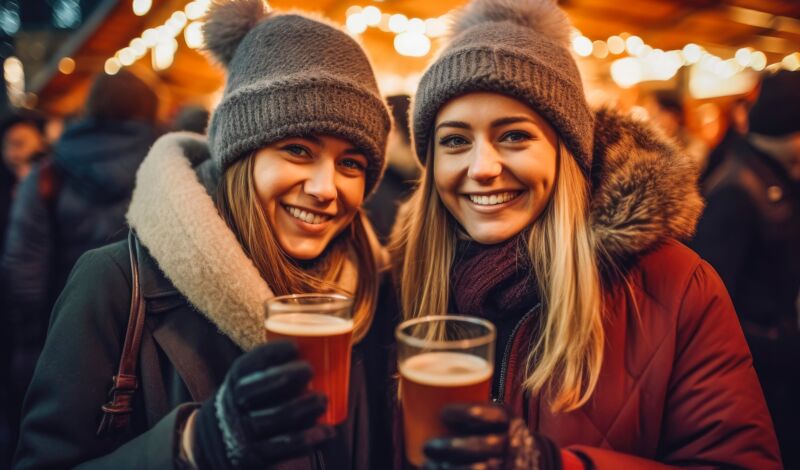 Freunde trinken Glühwein auf Weihnachtsmarkt