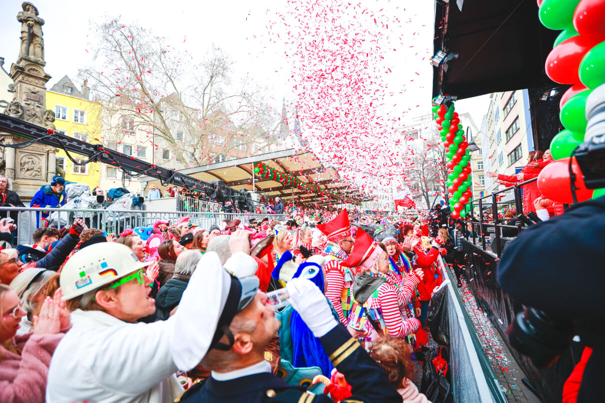 Jecke feiern an Weiberfastnacht bei der Eröffnung des Straßenkarnevals auf dem Alter Markt in Köln.