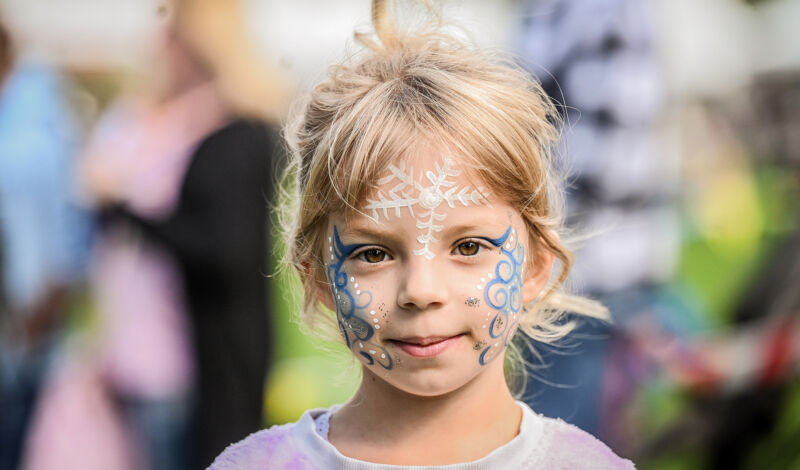 Das Foto zeigt ein Mädchen mit Kinderschminke im Gesicht.