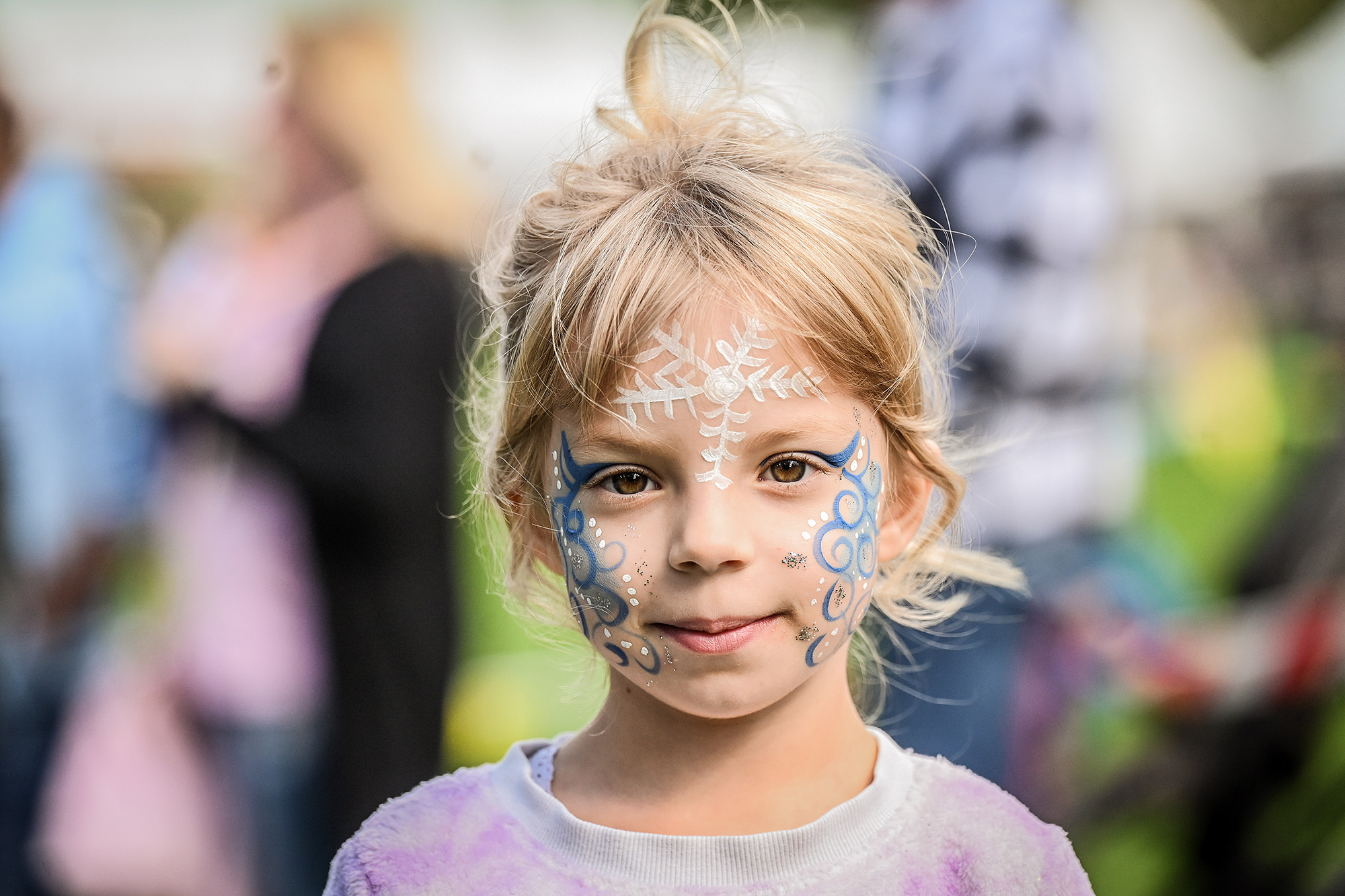 Das Foto zeigt ein Mädchen mit Kinderschminke im Gesicht.