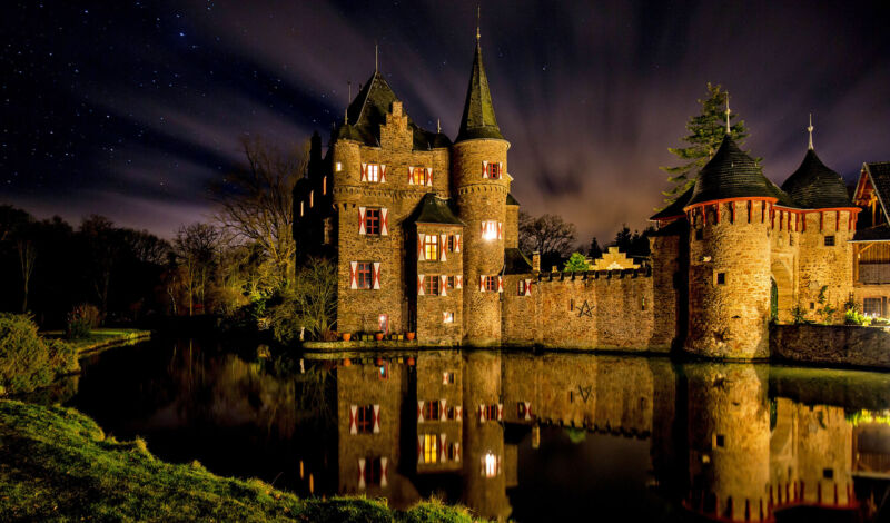 Beleuchtete Burg Satzvey in der Eifel bei Nacht.