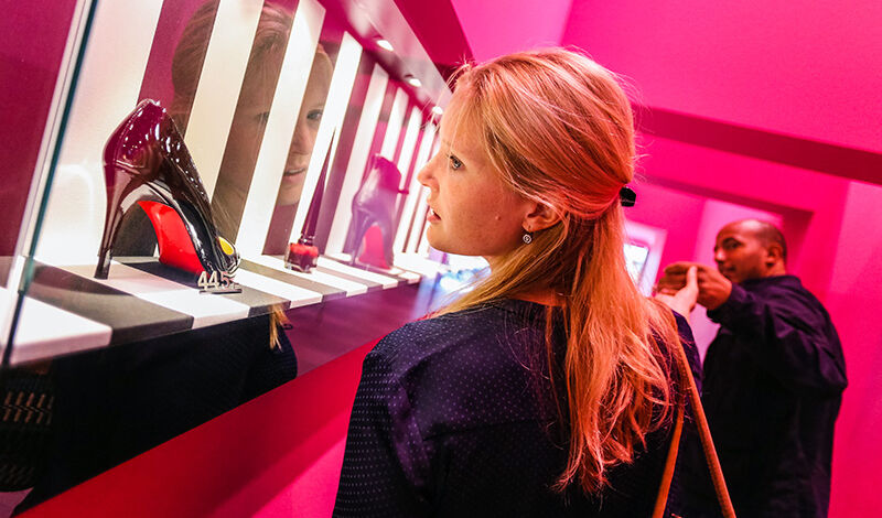 Frau schlendert durch pinkfarbene Galerie auf der Mittelstraße in Köln.