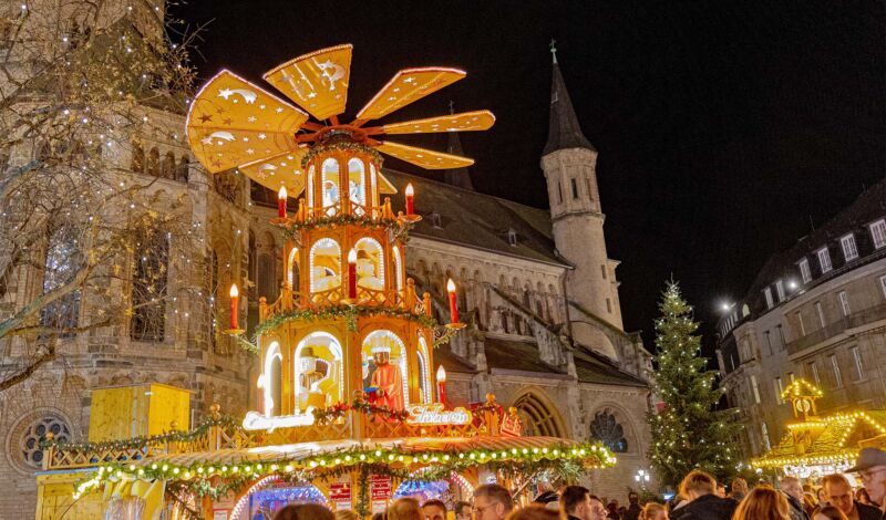 Die Riesenpyramide auf dem Bonner Weihnachtsmarkt, im Hintergrund das Bonner Münster