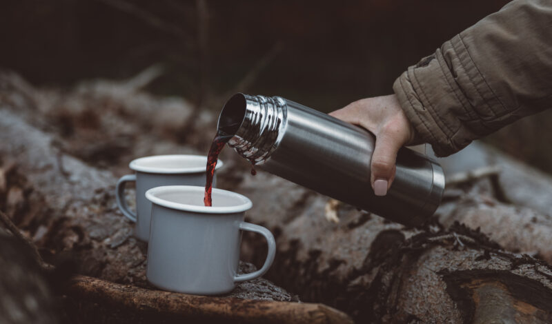 Im Wald wird Glühwein in Becher geschüttet