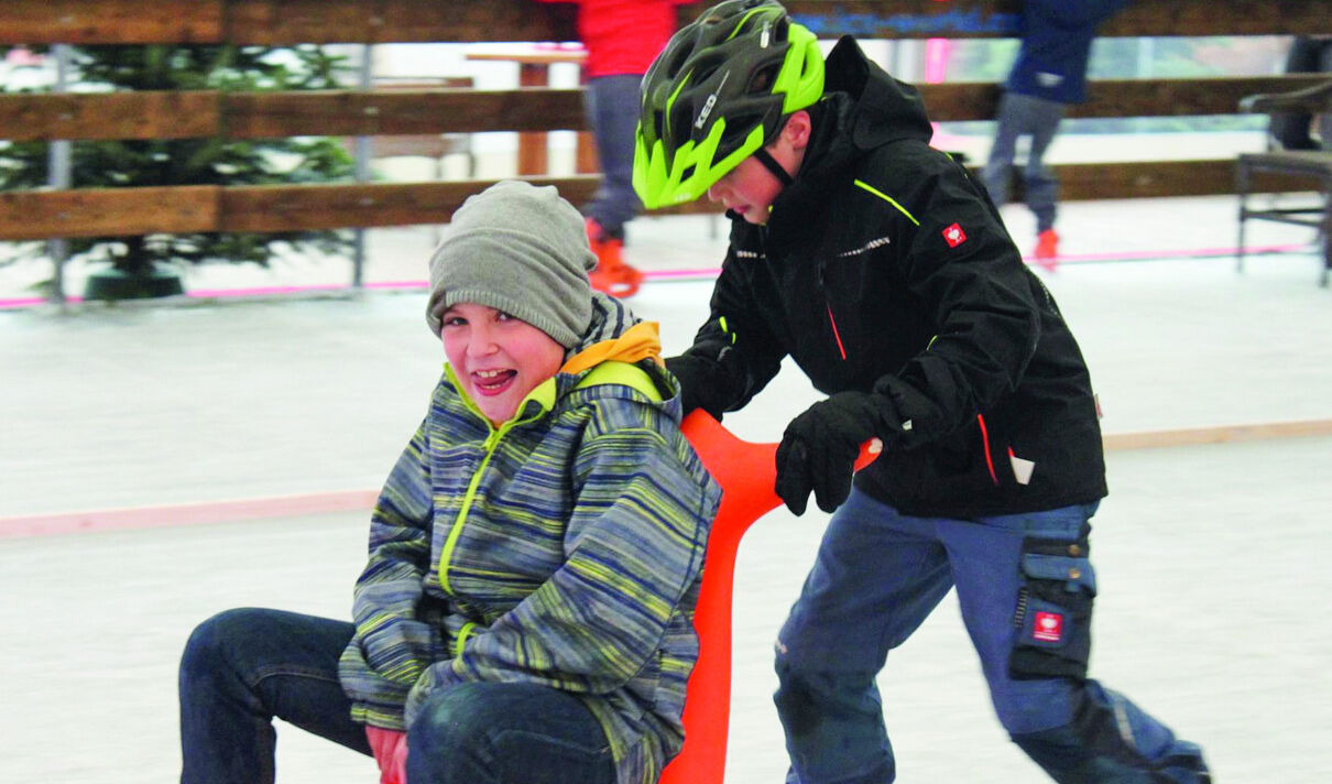 Das Foto zeigt zwei Kinder beim Spielen auf dem Eis.