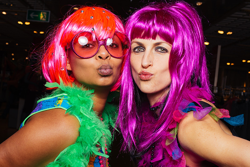 Zwei Frauen kostümiert mit bunten Perücken