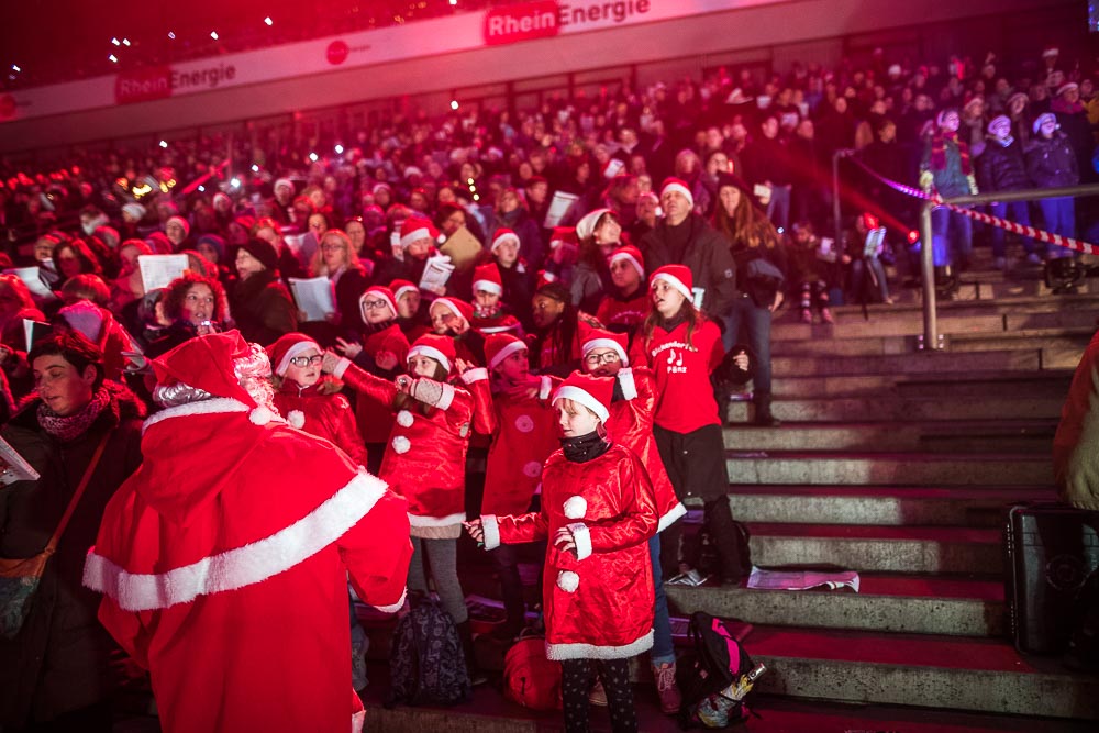 Tausende Besucher im Kölner Rheinenergie-Stadions singen Weihnachtslieder