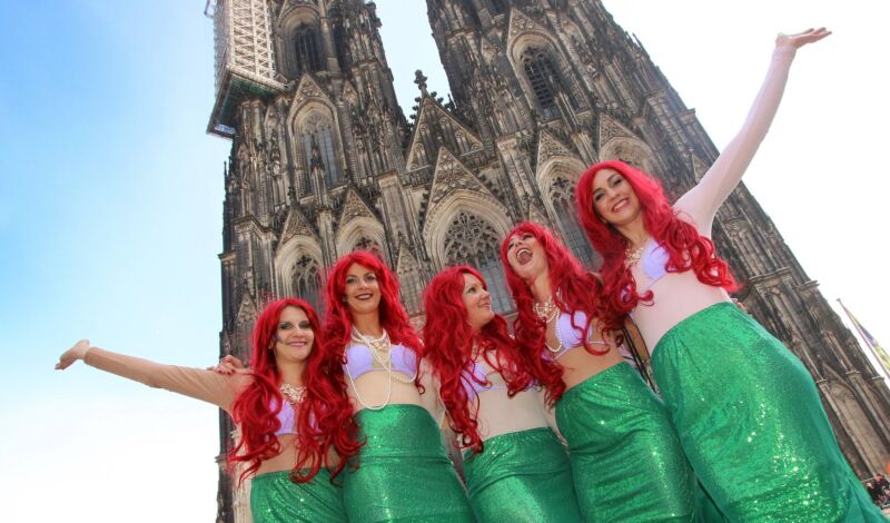 gruppe von Frauen posieren als Arielle kostümiert vor dem Kölern Dom