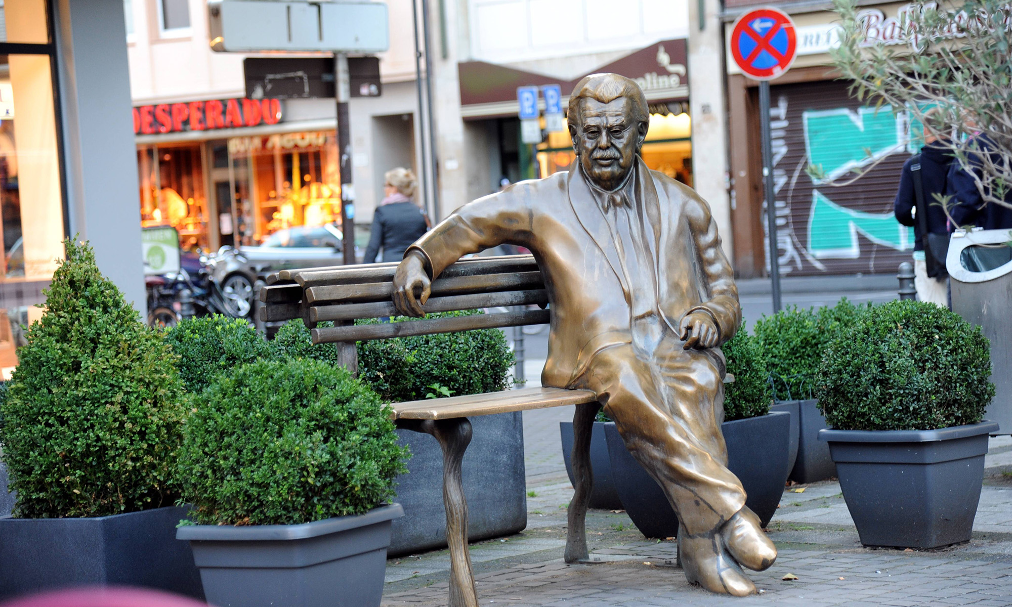 Ein Bronzedenkmal Wily Millowitschs am Willy-Millowitsch-Platz am Ende der Breite Straße.